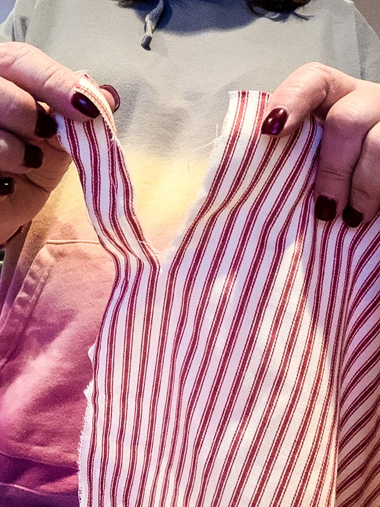Ripping red and white ticking fabric into 8 inch strips.