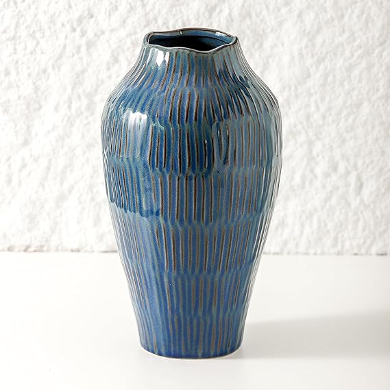 Glazed ceramic vase in shades of blue with vertical grooves.