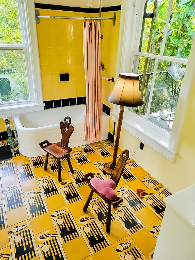 A bathroom in the Hemingway home in Key West, Florida. It has art deco tile in gold and black. 