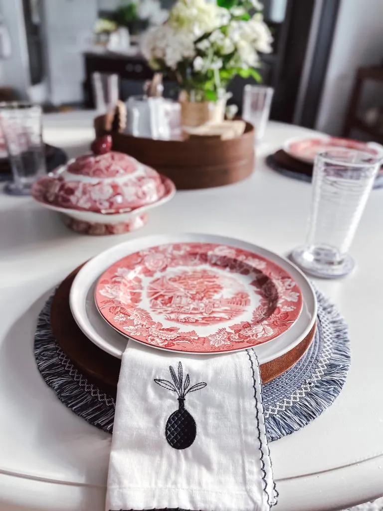 A budget-friendly patriotic table setting using mixed linens, patterned napkins, and pops of red, white, and blue.