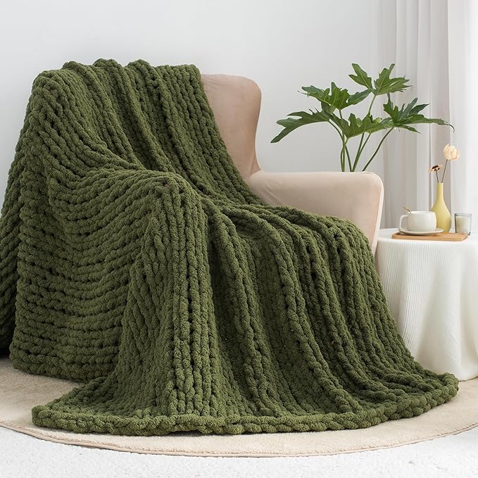 Olive green chunky knit throw blanket draped over a chair.