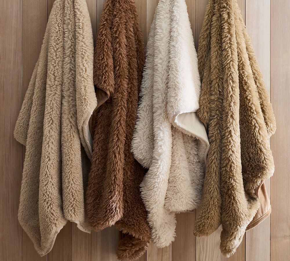 Four throw blankets in various shades of brown and cream.