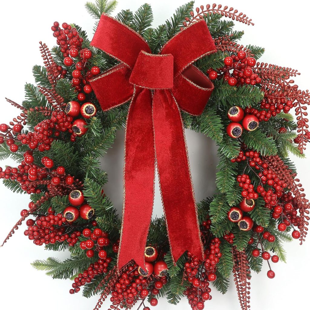 Lush green Christmas wreath adorned with red berries and a large red velvet bow