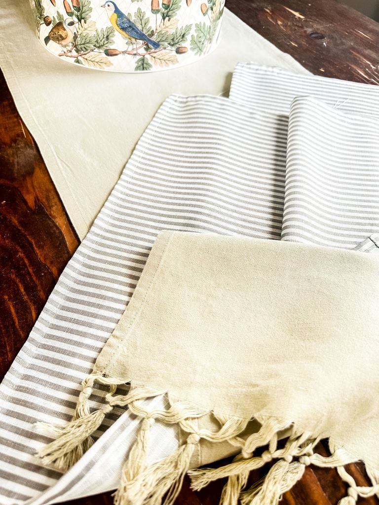Striped napkins and a solid table runner with tassels. 