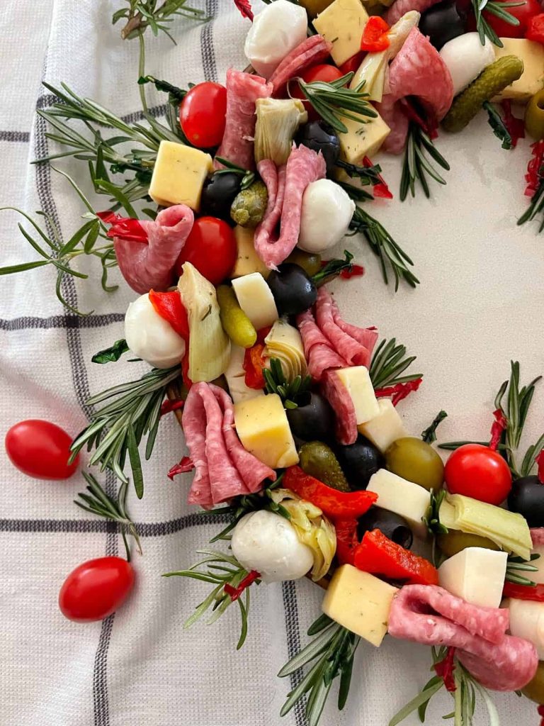A Christmas charcuterie board made with various cheeses, olives, and meats. 