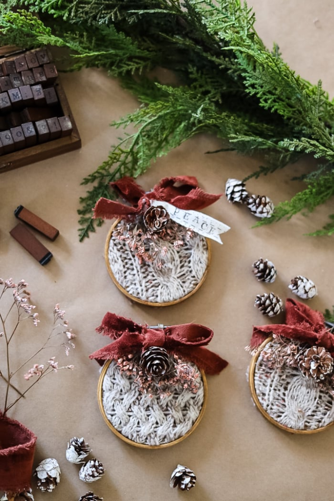 DIY Christmas ornaments made by thrift store sweaters, embroidery hoop, pinecones and ribbon.
