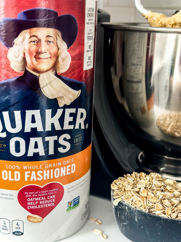 Quaker Oats Old Fashioned oatmeal box, a mixer, and a measuring cup with oats in it.