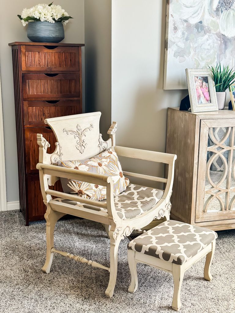 An elegant, antique French-style chair and matching ottoman in a light, neutral color palette, adding a touch of vintage charm to the room.