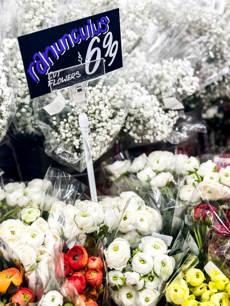 Colorful ranunculus flowers along with babies breath in a store ready for sale. 