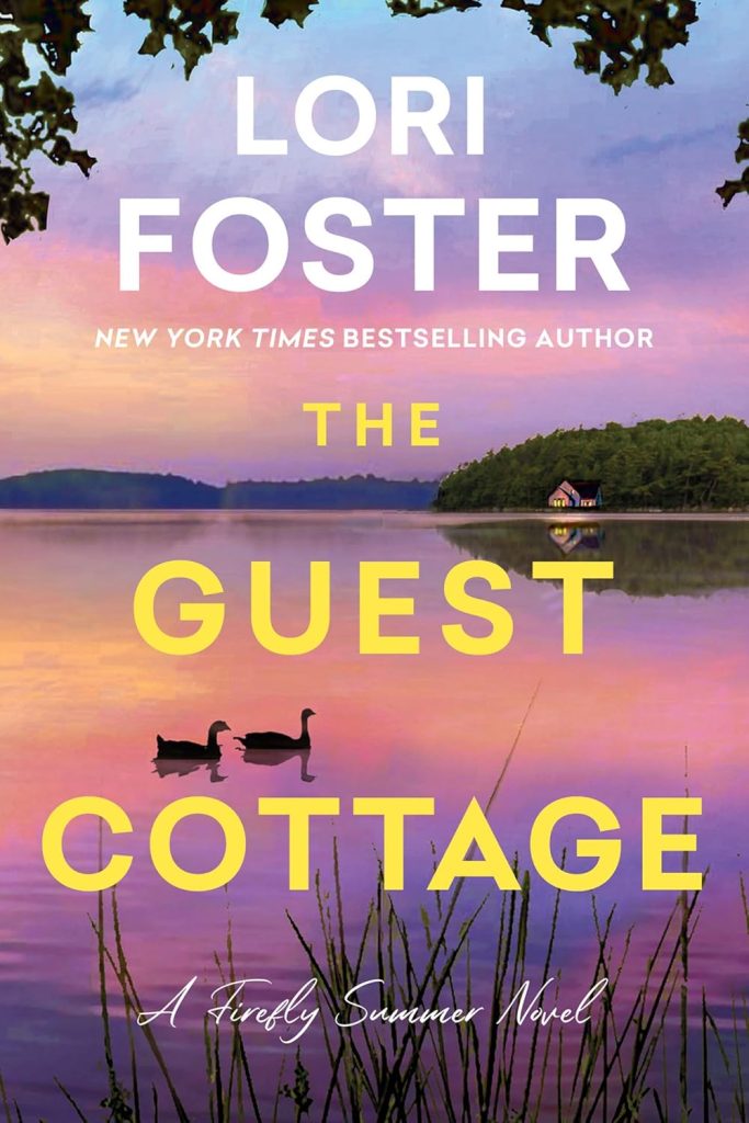 A new book called The Guest Cottage by Lori Foster. It has a picture of a lake with a cottage nestled among some trees on the front cover. 