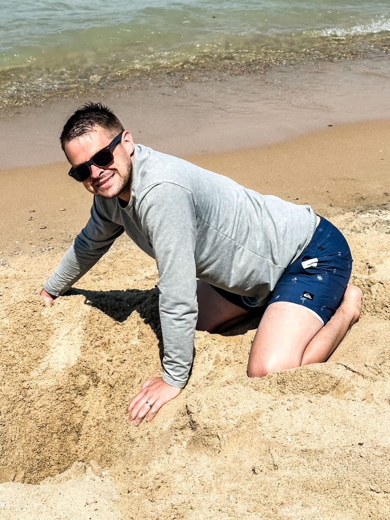 Young man building in the sand on a Lake Michigan beach on the Leelanau Peninsula.