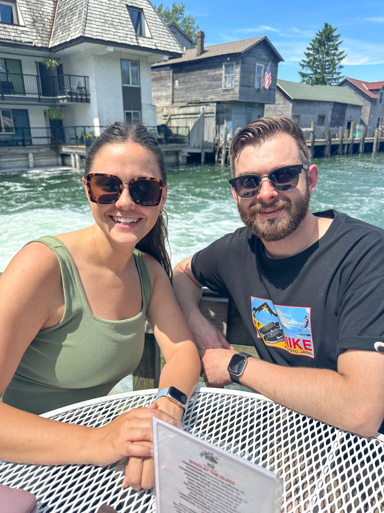 Couple dining outdoors at The Cove restaurant in Leland Michigan with views of Fishtown and the waterway.