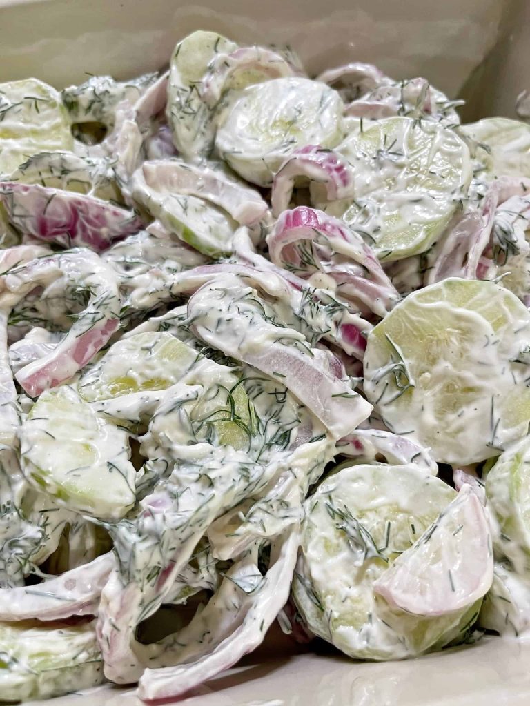 Creamy cucumber salad with fresh dill, thinly sliced red onion, and a tangy dressing.