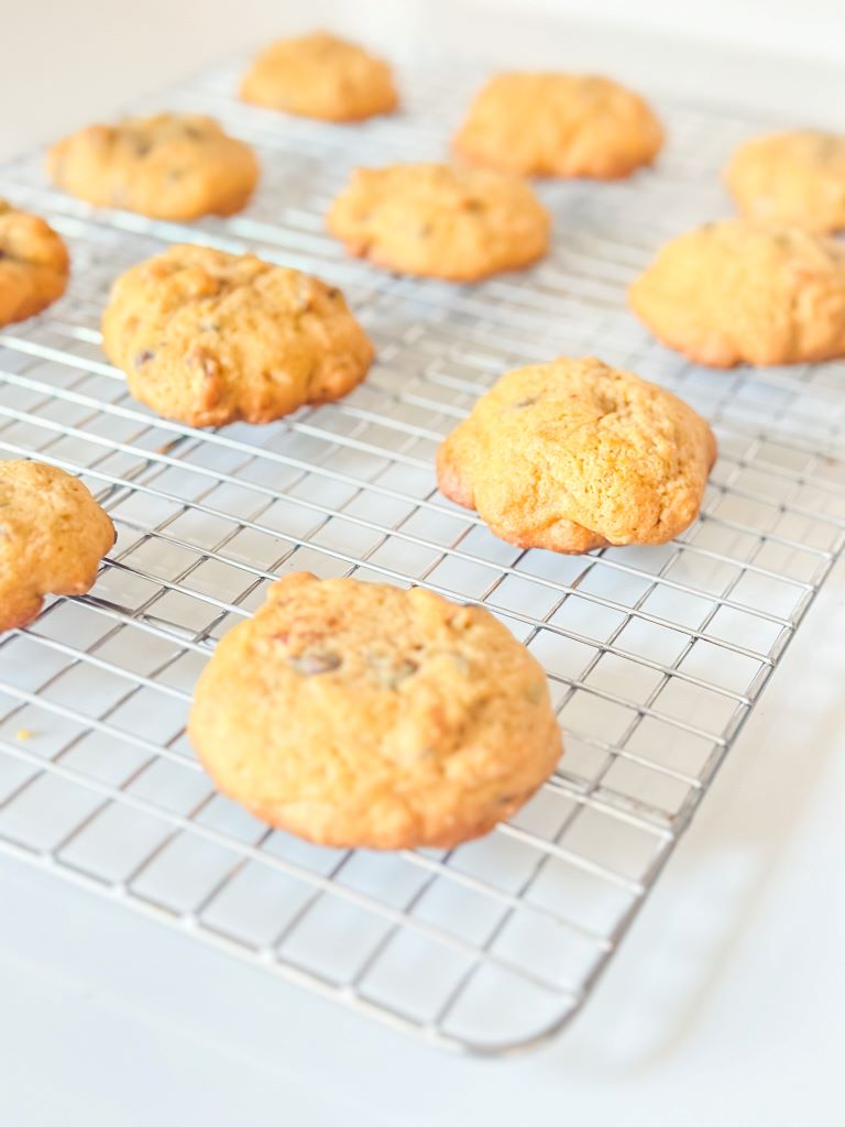 Soft-baked nutty pumpkin chocolate chip cookies stacked on a plate for a cozy fall treat.